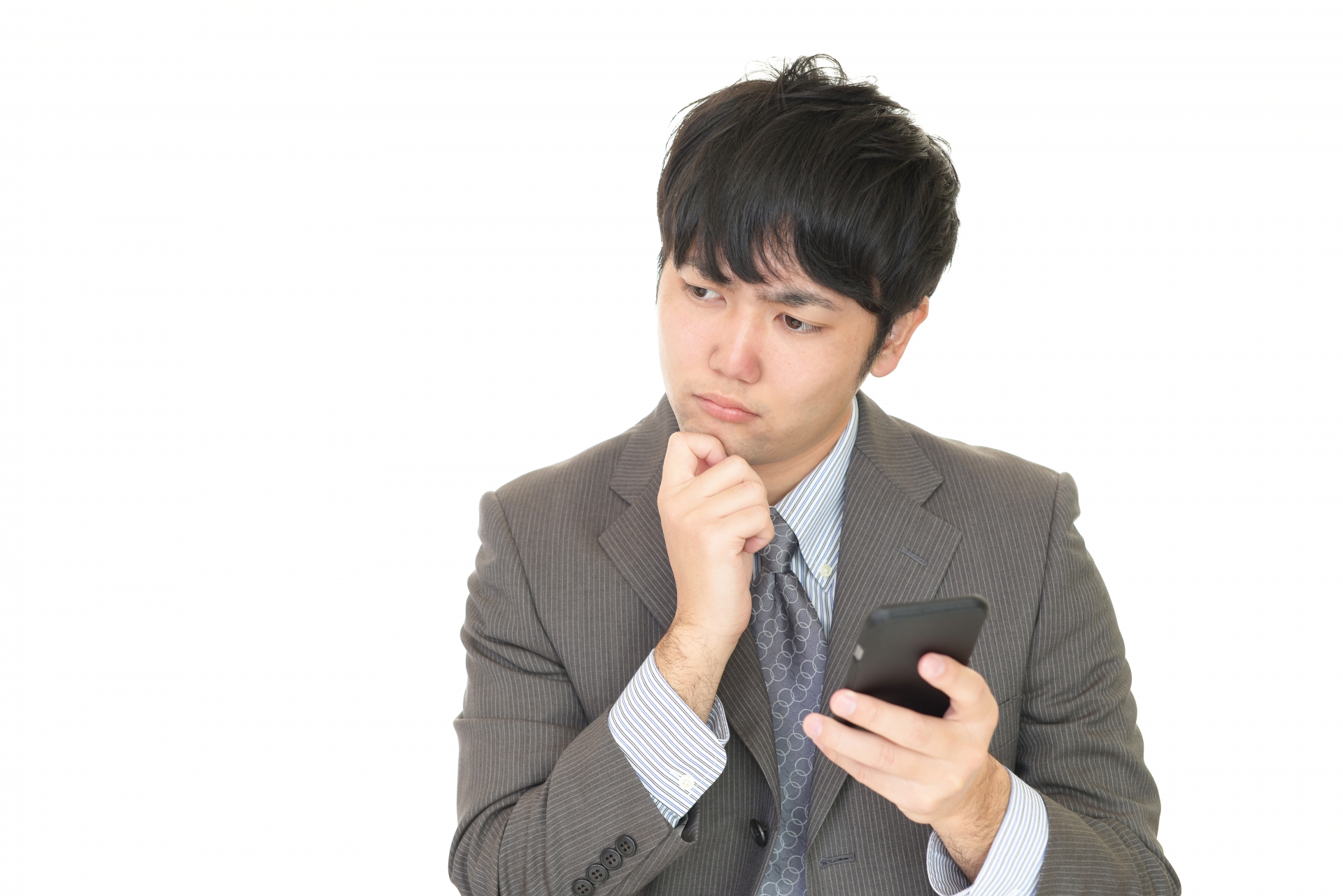 スマートフォンを持って悩む男性